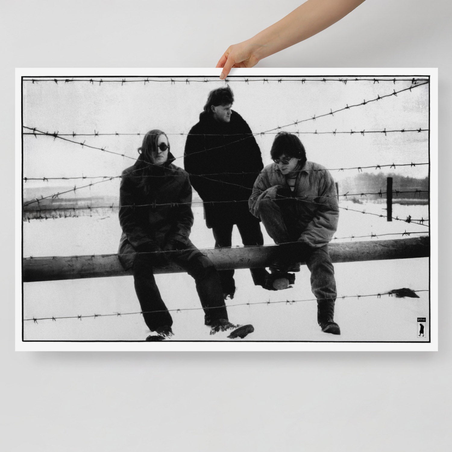 A hand holds large poster of Egor Letov and Grazhdanskaya Oborona band sitting in a snowy field behind barbed wire. www.egorletov.com