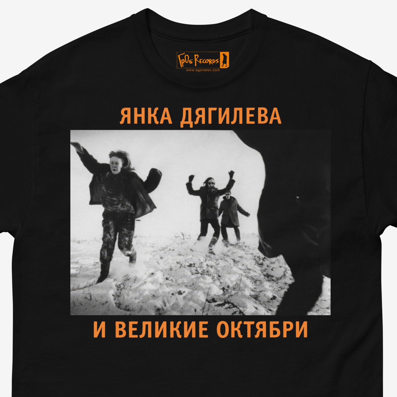 Official black unisex T-shirt with large black and white photo of Egor Letov and Yanka Dyagileva running in a snowfield. Featuring Янка Дягилева и Великие Октябри text in Cyrillic. Closeup print photo with GrOb Records logo seen on the branded necktag. www.egorletov.com